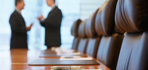Side view of two blurred businessmen talking in conference room