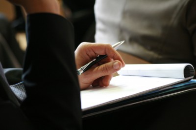 man's hand using a pen noting on notepad