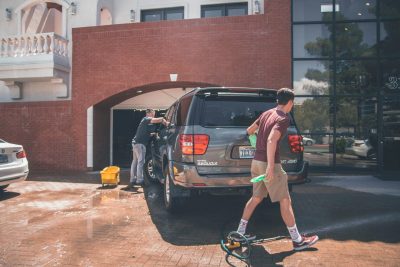 2 men cleaning a grey SUV