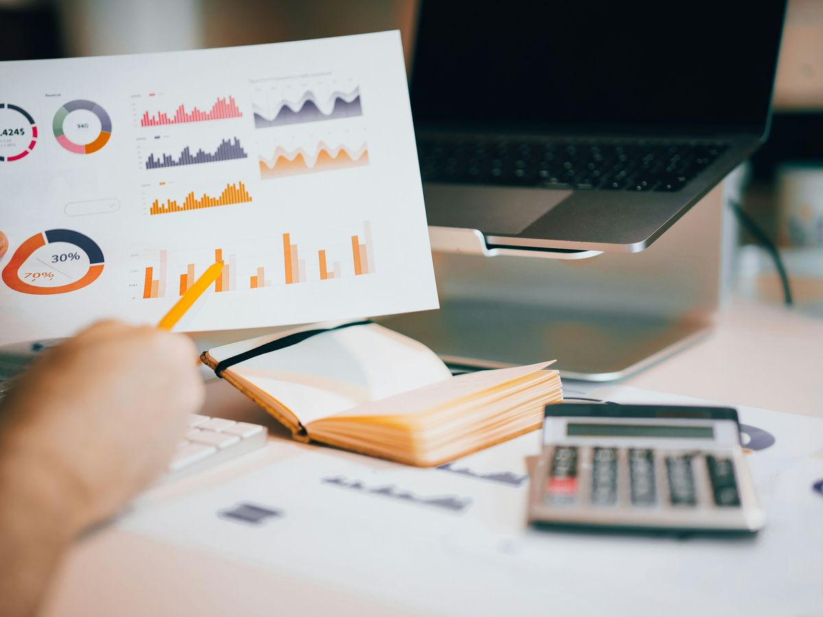 a person holding a piece of paper over a laptop