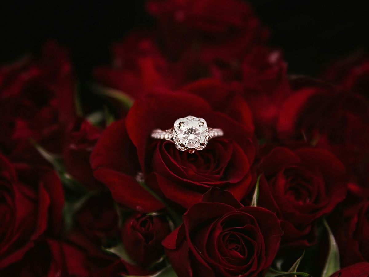 silver-colored ring on top of red roses